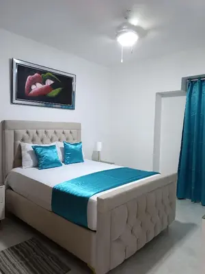 a bedroom with a large bed with blue pillows at Boca del Mar III, apartamento 706A in Boca Chica