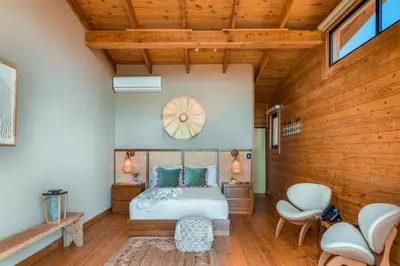 a bedroom with a bed and two chairs at The Grand Forest Jarabacoa in Jarabacoa
