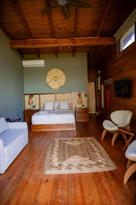 a bedroom with a bed and a couch and a table at The Grand Forest Jarabacoa in Jarabacoa