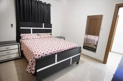 a bedroom with a bed and a dresser and a mirror at Lujoso y confortable apartamento en Santo Domingo in Santo Domingo