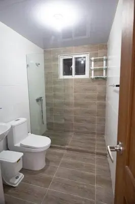 a bathroom with a toilet and a glass shower at Lujoso y confortable apartamento en Santo Domingo in Santo Domingo