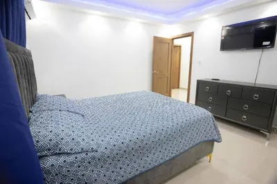 a bedroom with a bed and a dresser and a television at Lujoso y confortable apartamento en Santo Domingo in Santo Domingo
