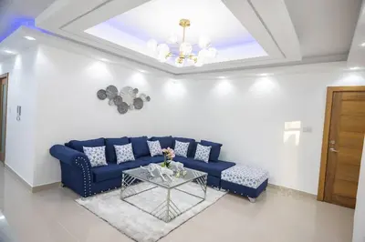 a living room with a blue couch and a glass table at Lujoso y confortable apartamento en Santo Domingo in Santo Domingo