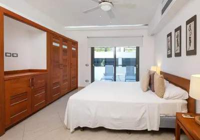 a bedroom with a white bed and a tv at Aligio Aparthotel, Beachfront, Las Terrenas in Las Terrenas