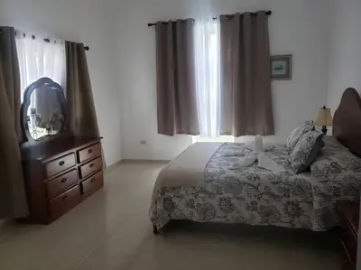 a bedroom with a bed and a dresser and a mirror at Apartamento Corozos 2-202 in Paraíso