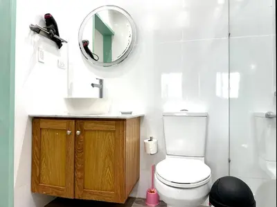 a bathroom with a white toilet and a mirror at Luperon candles apartment in Puerto de Luperon