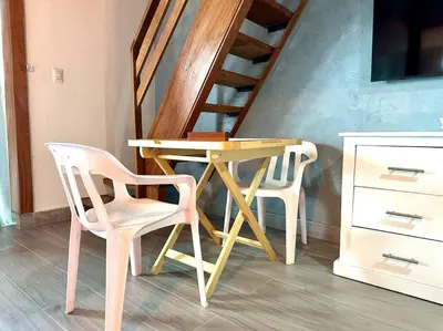 a wooden table and two chairs next to a staircase at Luperon candles apartment in Puerto de Luperon