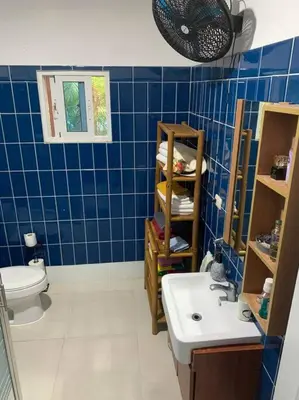 a blue tiled bathroom with a sink and a toilet at Villa en boca chica in Cuevas