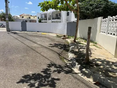 a tree on the side of a road next to a fence at Cozy Apartment in the heart of Santiago in Santiago de los Caballeros