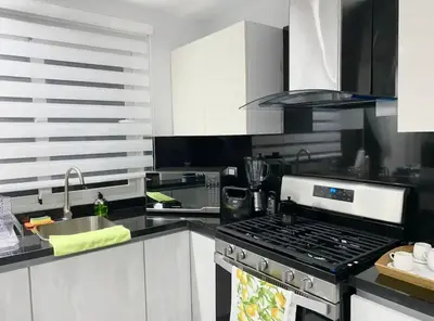 a kitchen with a stove top oven next to a sink at PiantiniTowerCentric SDQ CityView in Santo Domingo