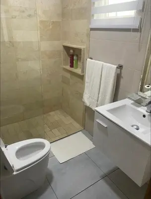 a bathroom with a toilet and a sink at PiantiniTowerCentric SDQ CityView in Santo Domingo
