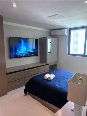 a bedroom with a bed with a tv on the wall at Arpel 6 SantoDomingo CItySeaView in Santo Domingo
