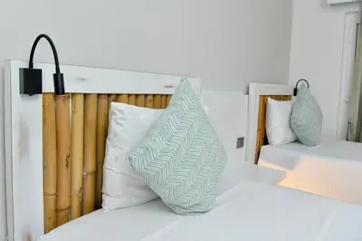 a bed with a green and white pillow on it at Honky Tonk Colonial in Santo Domingo