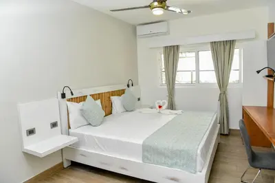 a bedroom with a white bed and a window at Honky Tonk Colonial in Santo Domingo