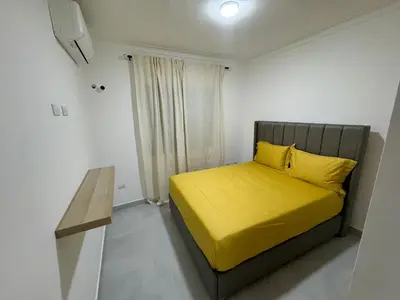 a bedroom with a yellow bed and a table at RESIDENCIAL LEGADO Apto 1 A in Azua