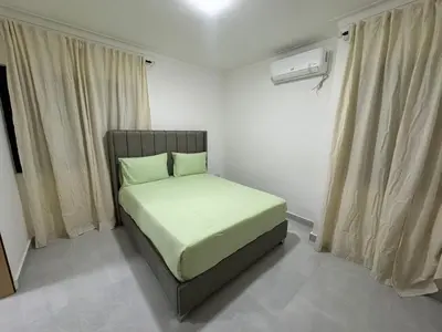 a small bedroom with a bed with green pillows at RESIDENCIAL LEGADO Apto 1 A in Azua