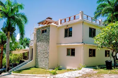 a house that is under construction with palm trees at Exclusive Mountain Villa with Ocean View near Puerto Plata in Maimón