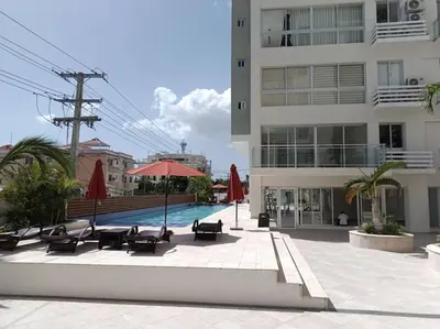 a pool with chairs and umbrellas next to a building at Boca del Mar III, apto 706B in Boca Chica