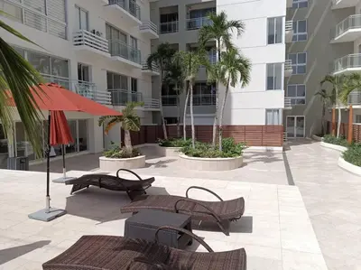 a patio with chairs and umbrellas in front of a building at Boca del Mar III, apto 706B in Boca Chica