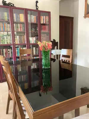 a glass table with a vase with flowers on it at Comfortable Apt Laura Virginia in Santo Domingo in Santo Domingo
