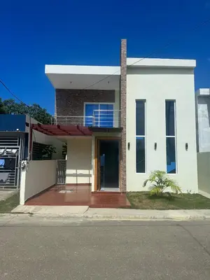 a white house with a door on a street at Villa familiar in San Felipe de Puerto Plata