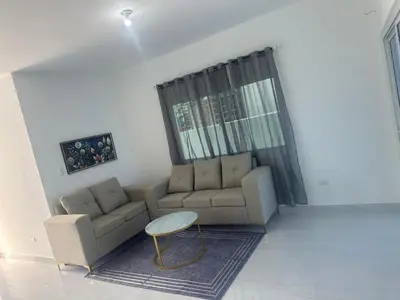 a living room with a couch and a table at Villa familiar in San Felipe de Puerto Plata