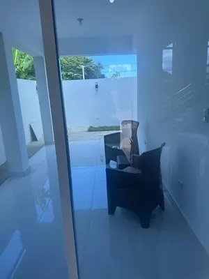 a black chair sitting in a room with a window at Villa familiar in San Felipe de Puerto Plata