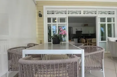 a white table and chairs with a vase on it at Playa Las Ballenas Oceanfront in Las Terrenas