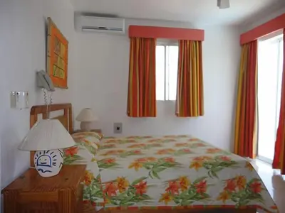 a bedroom with a bed and a table with a lamp at Hotel Angel Gabriel in Boca Chica