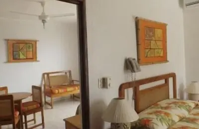 a room with a bedroom with a bed and a mirror at Hotel Angel Gabriel in Boca Chica