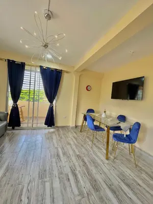a dining room with blue chairs and a table at Acogedor apartamento in Azua de Compostela
