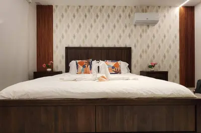 a bedroom with a large bed with white sheets at 1st Line view in San Pedro de Macorís
