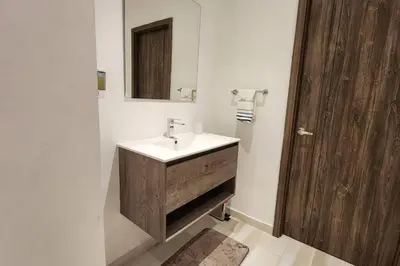 a bathroom with a sink and a wooden door at 1st Line view in San Pedro de Macorís