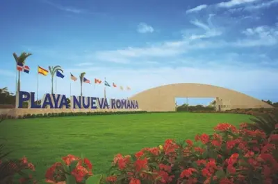 a building with a sign in front of a field of flowers at 1st Line view in San Pedro de Macorís