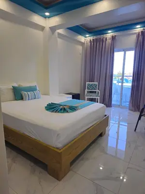 a bedroom with a large bed and a window at Hotel Gutz in San Felipe de Puerto Plata