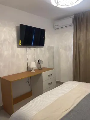 a bedroom with a bed and a desk with a tv at Hermoso apto amueblado a 5 minutos de downtown Punta Cana in Punta Cana