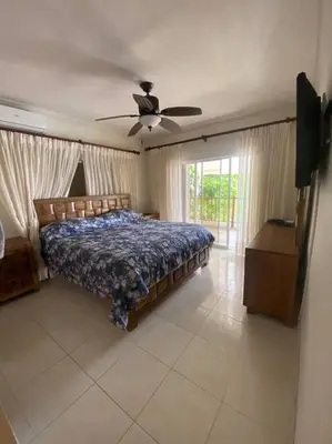 a bedroom with a bed and a ceiling fan at Apartment with ocean front view in Juan Dolio