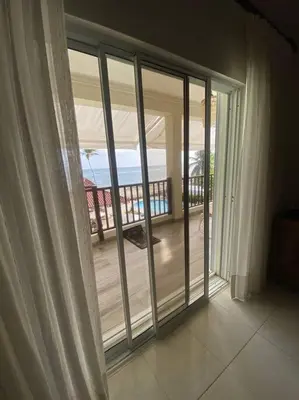 a room with a sliding glass door looking out at the ocean at Apartment with ocean front view in Juan Dolio