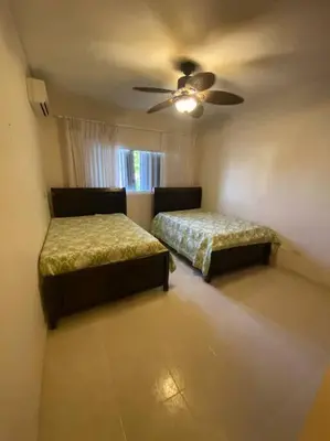 a bedroom with two beds and a ceiling fan at Apartment with ocean front view in Juan Dolio