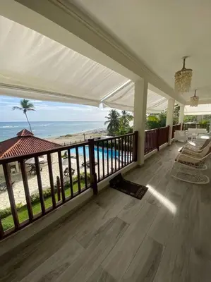 a large porch with a view of the beach at Apartment with ocean front view in Juan Dolio