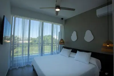 a bedroom with a white bed and a large window at Las Golondrinas Cabarete in Cabarete