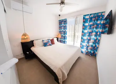 a small bedroom with a bed and a window at Las Golondrinas Cabarete in Cabarete