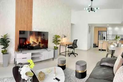 a living room with a couch and a tv at Comfy 2BR City Center Condo in Los Prados