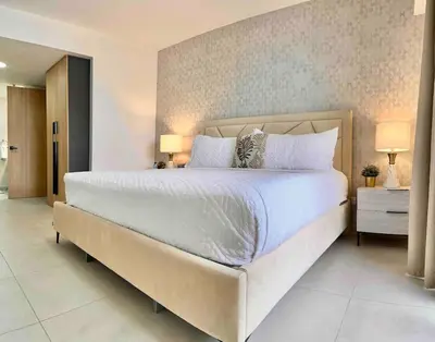 a bedroom with a large white bed and two lamps at Comfy 2BR City Center Condo in Los Prados