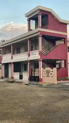 a large pink building with a balcony on a street at Sábana de la mar in La Tentación