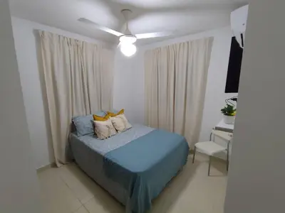 a bedroom with a blue bed and a ceiling fan at Your Tropical HouseRD in La Francia