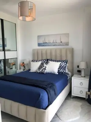 a bedroom with a bed with blue sheets and pillows at The Peña family suite in Punta Cana
