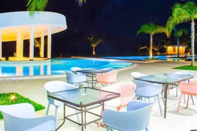 a patio with tables and chairs next to a swimming pool at The Peña family suite in Punta Cana