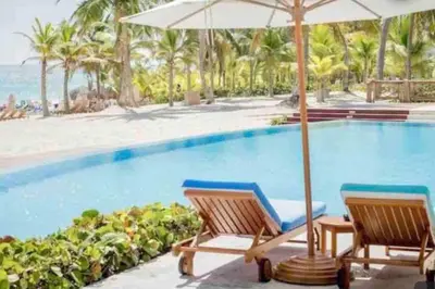 two chairs and an umbrella next to a swimming pool at The Peña family suite in Punta Cana