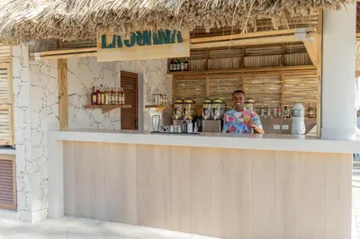 a man standing at a bar in a restaurant at Bahia Principe Grand Punta Cana - All Inclusive in Punta Cana